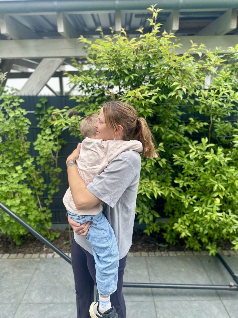 Eine Mama, die ihren Sohn fest im Arm hält.